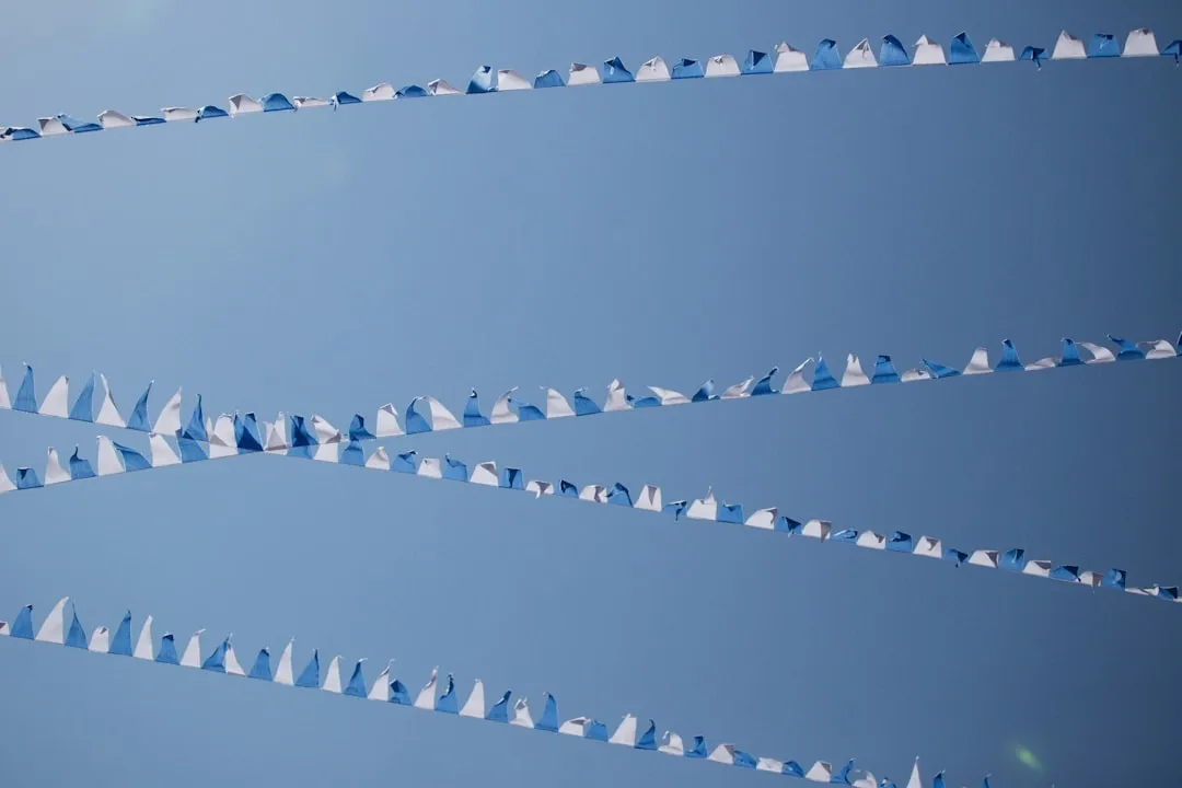 a group of kites flying through a blue sky
