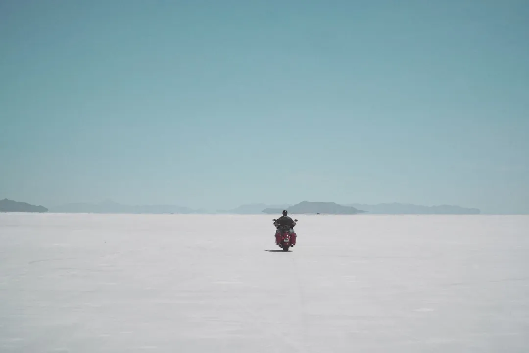 a person riding a snowmobile in a large flat area