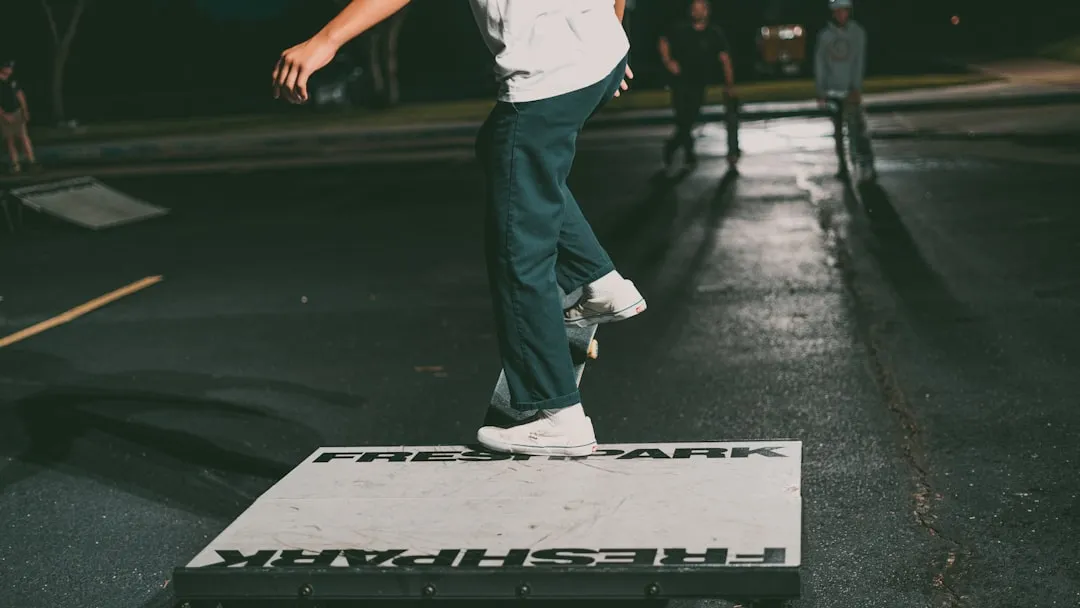man in white shirt and black pants standing on black and white road during daytime