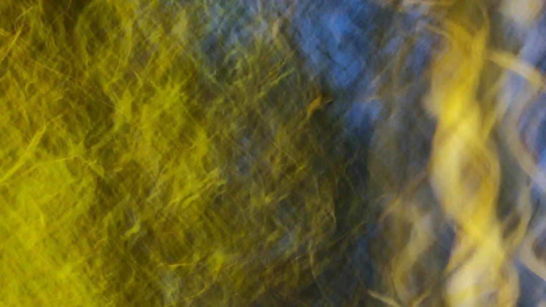 Yellow and blue abstract strokes create a blur.