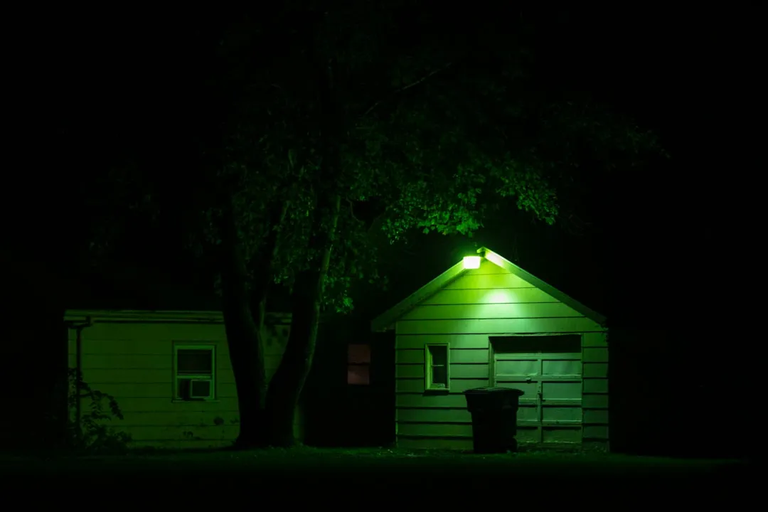 A green light shines on the roof of a house
