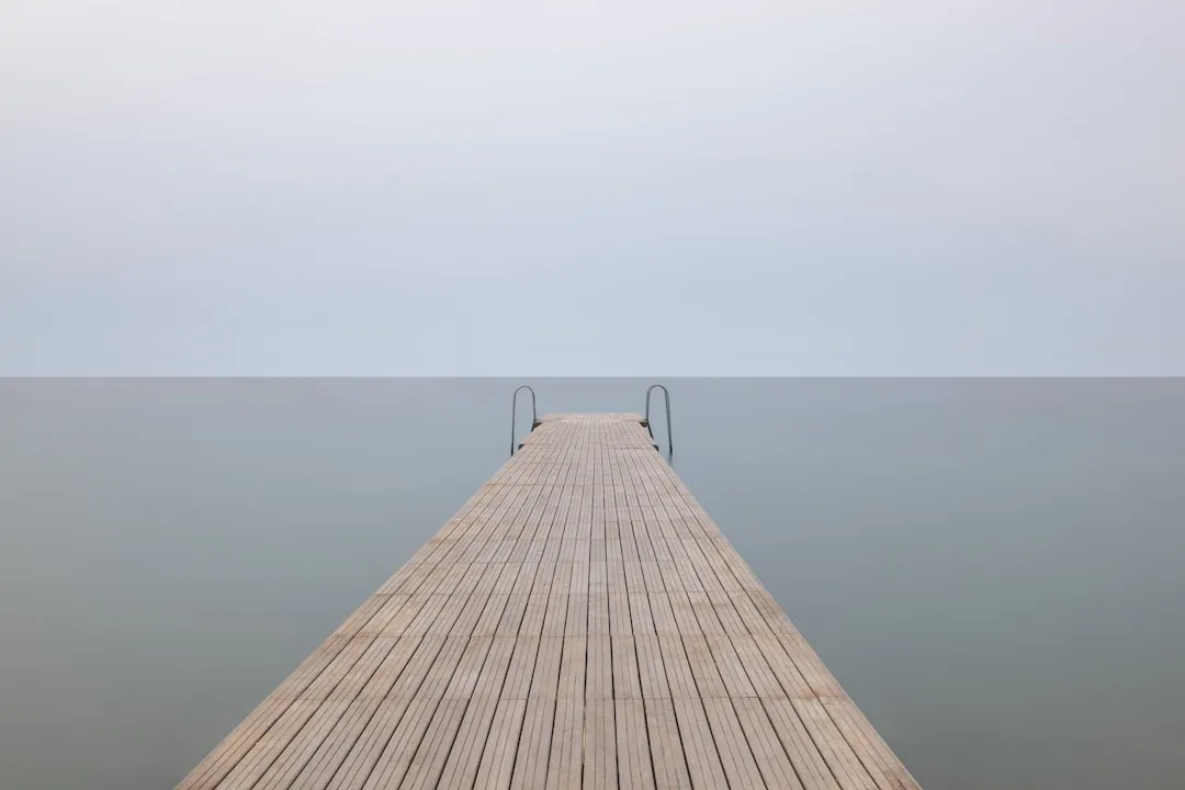 brown wooden dock with cloudy sky